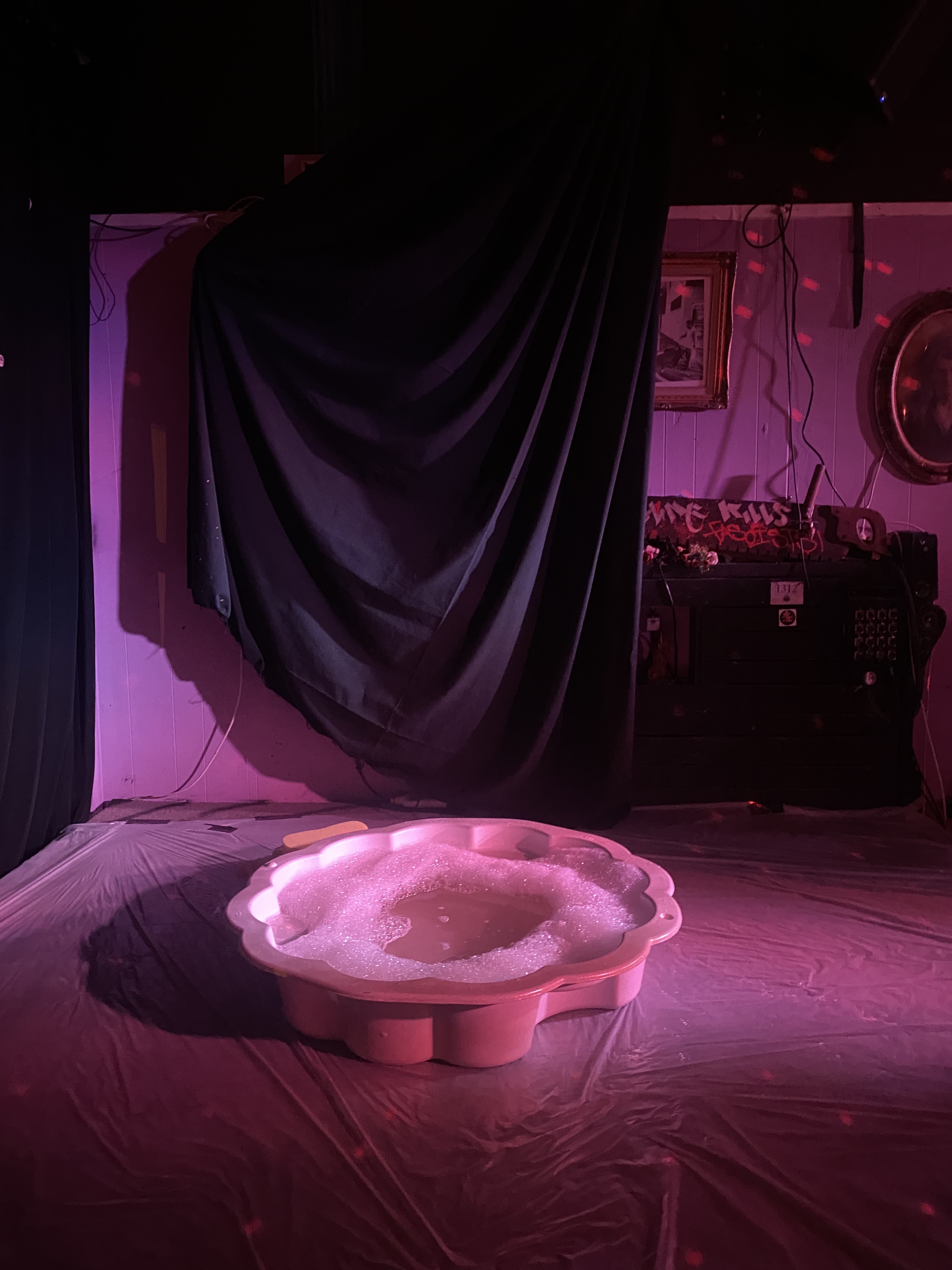 A conch shell shaped small plastic bathtub filled with soapy water sat atop a stage, all pink tones and anticipatory sexy lighting.