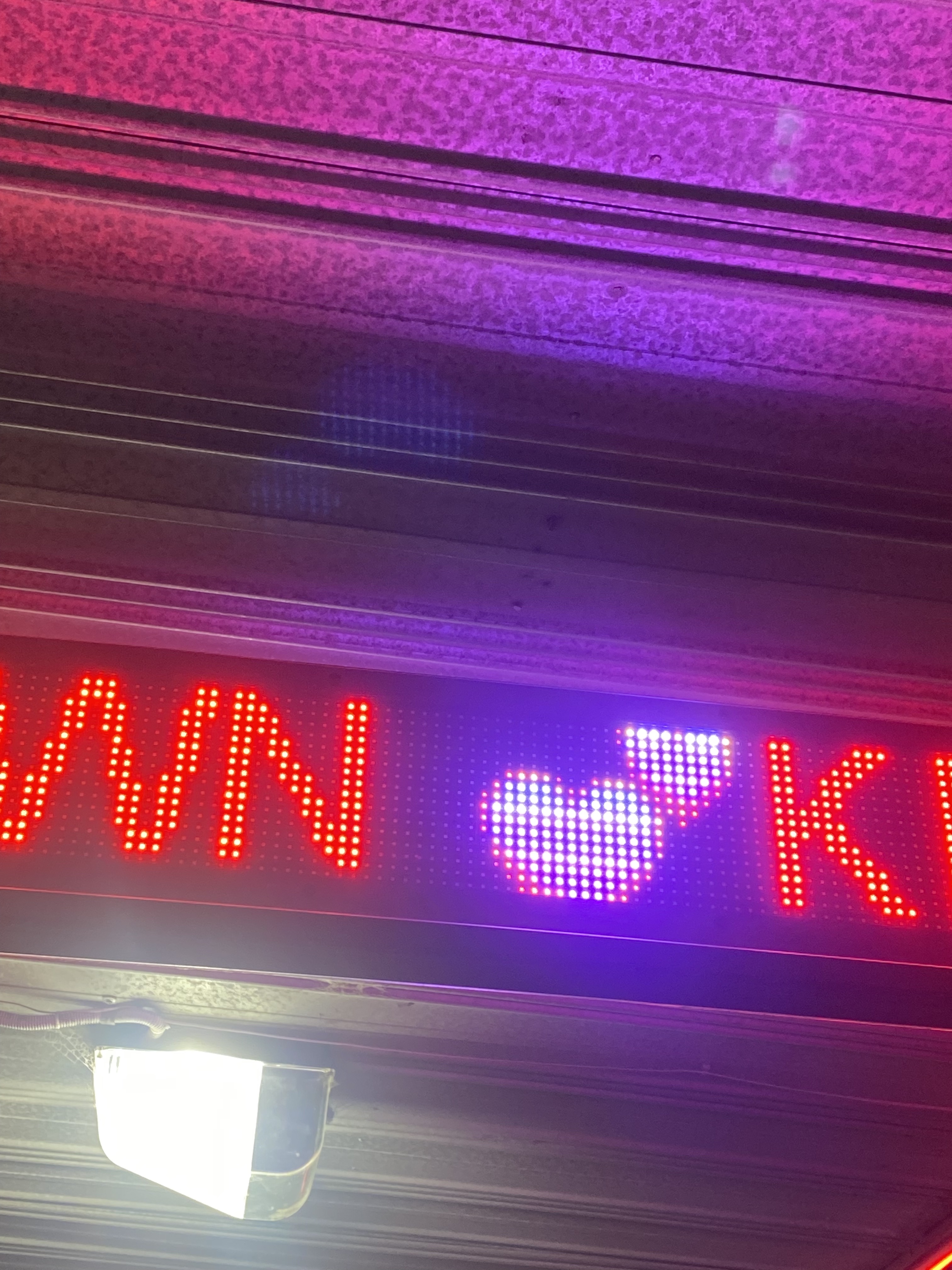 Neon sign with a love heart in pink and red LED.